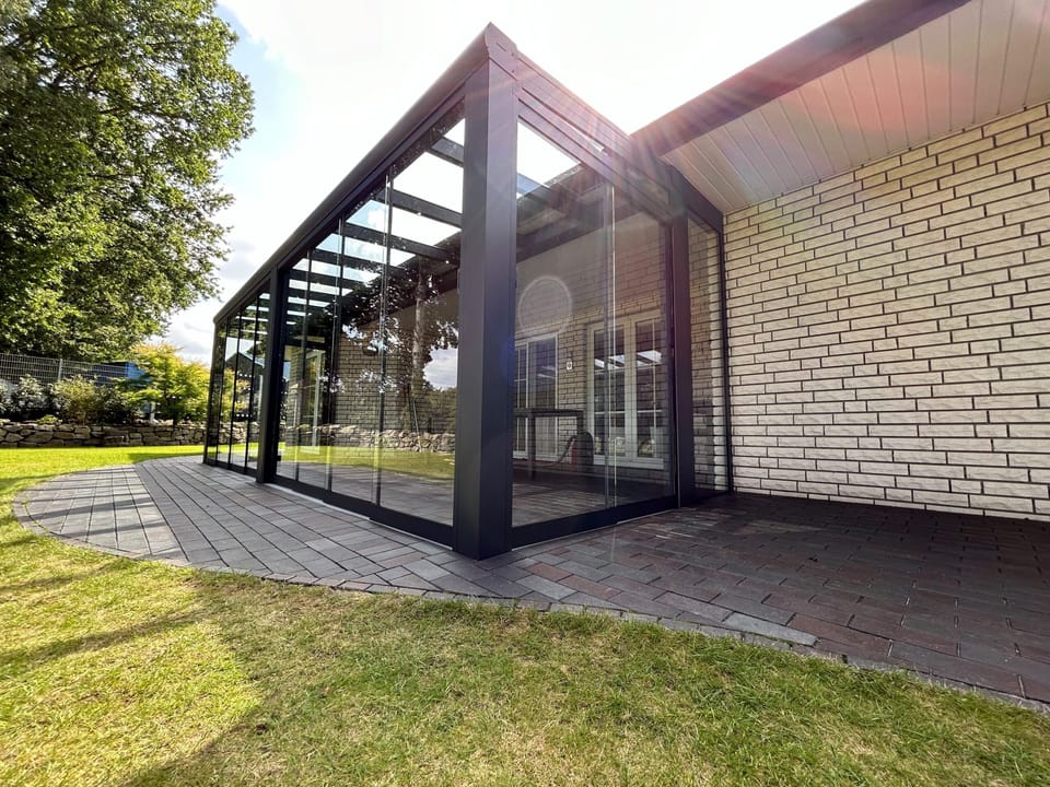 Wintergarten an einem Haus mit heller Klinkerfassade