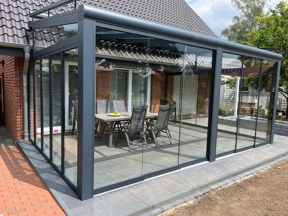 Kaltwintergarten mit Glasschiebewänden auf einer Klinkerterrasse