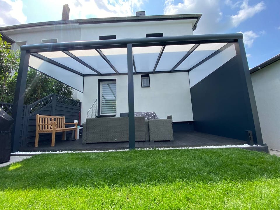 Terrassendach mit Glasdach über einer Lounge-Terrasse