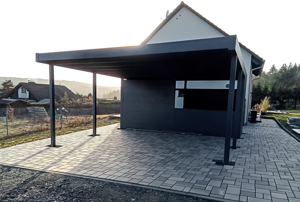 Carport am Haus mit Pflasterfläche